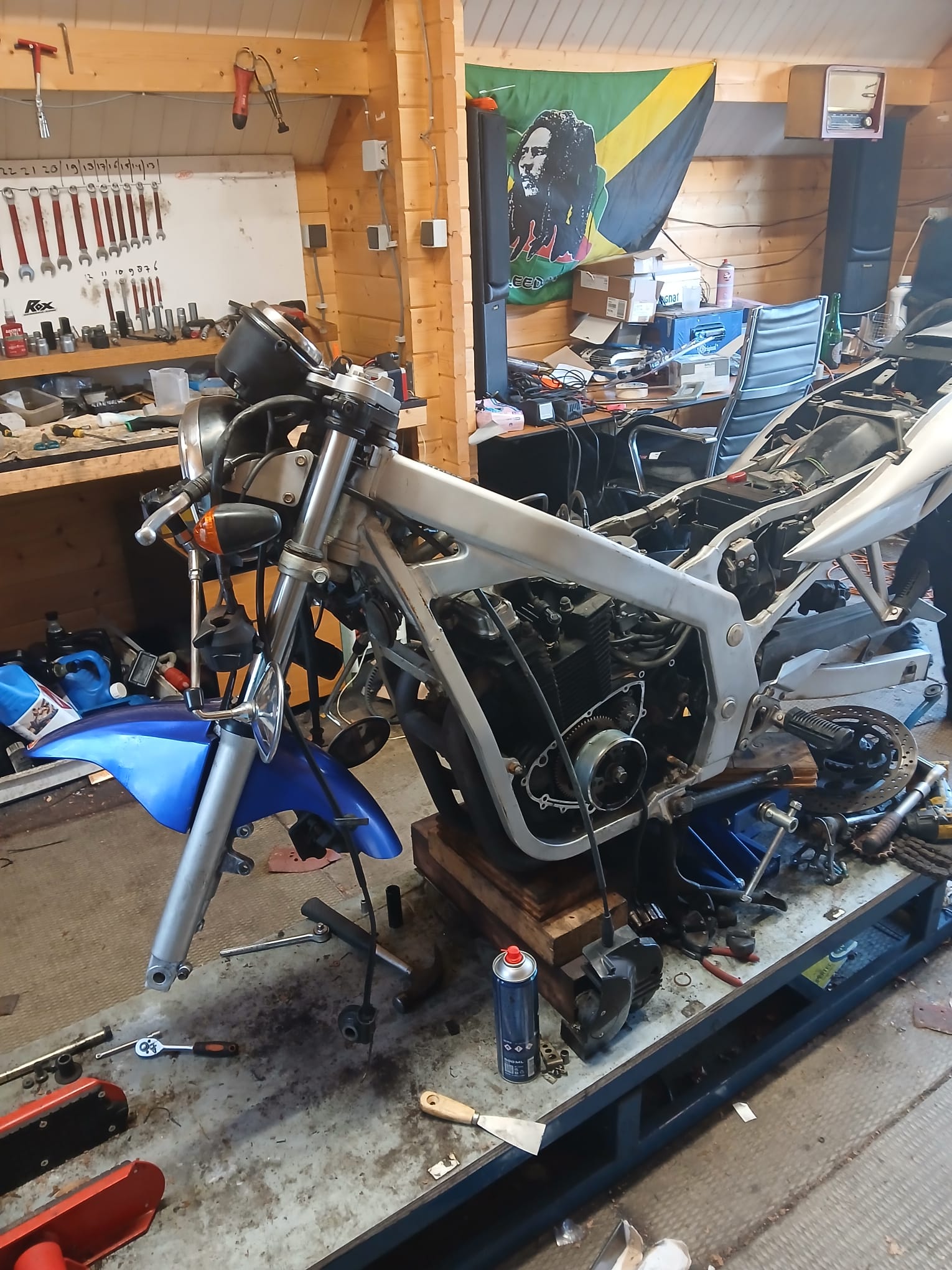 Arjan werkt met een fijn gereedschap aan de bekabeling van een KTM in de werkplaats